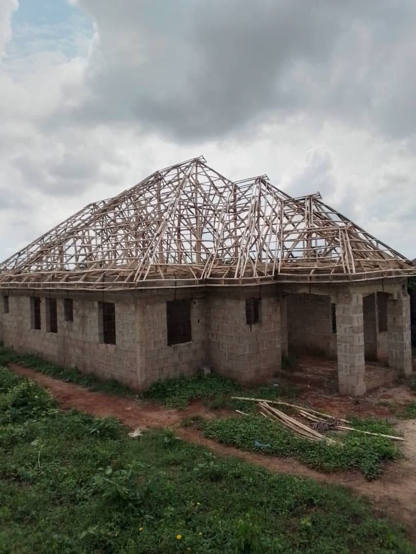 Building under construction with roof timber skeleton — cost of building materials Lagos 2026