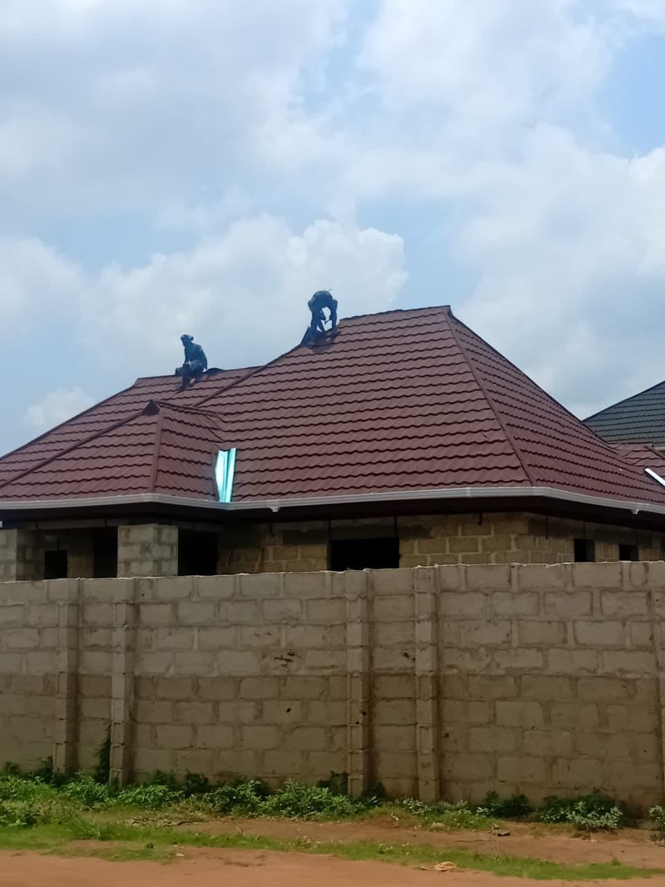 Stone tiles being installed on a residential roof